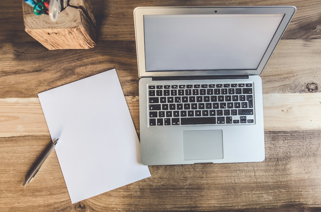 writer at wooden desk with notebook